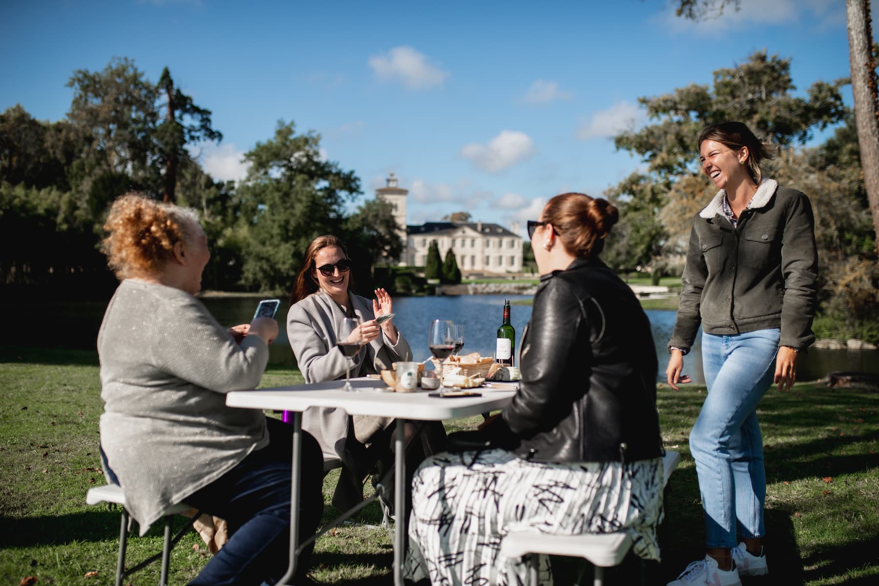 Guests sharing a glass of wine at a table on a château lawn