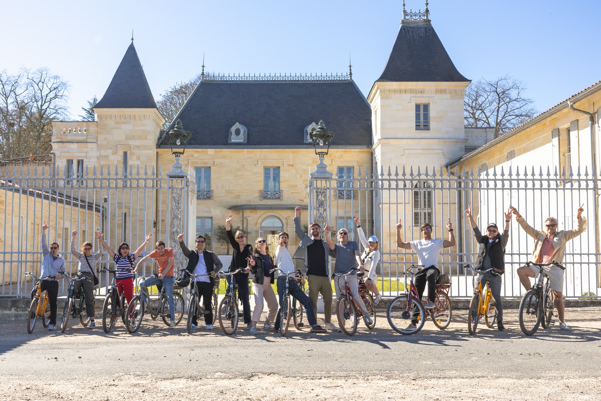 Voyageurs partageant un déjeuner et des vins de Bordeaux autour d’une grande table
